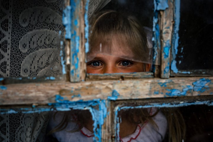 Antonina, de 9 años, mira a través de una ventana de su escuela, en el sur de Ucrania.