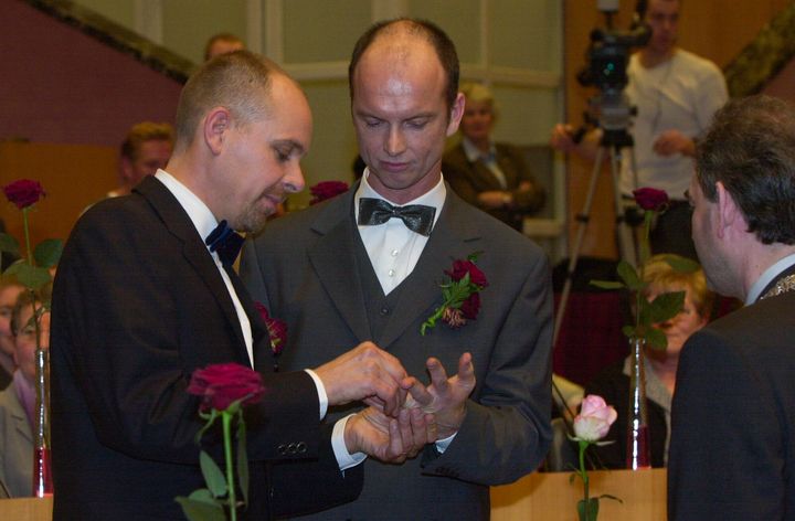 Ο Gert Kasteel, αριστερά, και ο Dolf Pasker, δεξιά, ανταλλάσσουν δαχτυλίδια κατά τη διάρκεια μιας γαμήλιας τελετής στο Δημαρχείο του Άμστερνταμ νωρίς την Κυριακή, 1 Απριλίου 2001. Το ζευγάρι ήταν μεταξύ τεσσάρων ζευγαριών που παντρεύτηκαν σύμφωνα με έναν νέο νόμο που τέθηκε σε ισχύ την 1η Απριλίου 2001, ο πρώτος τέτοιος νόμος στον κόσμο που επιτρέπει γάμους ομοφυλόφιλων με ίσα δικαιώματα. Ο γάμος ομοφύλων είναι πλέον νόμιμος σε 28 χώρες, συμπεριλαμβανομένου του μεγαλύτερου μέρους της Δυτικής Ευρώπης, καθώς και στο αυτοδιοικούμενο νησί της Ταϊβάν. (AP Photo/Peter Dejong)