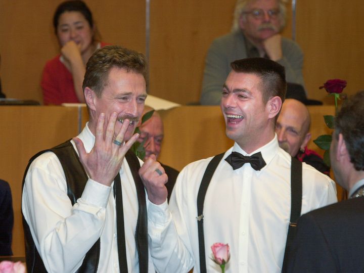 Ο Frank Wittebrood, αριστερά, και ο Peter Wittebrood-Lemke, δείχνουν τα δαχτυλίδια τους στον δήμαρχο του Άμστερνταμ, Job Cohen, δεξιά, αφού αντάλλαξαν όρκους στο Δημαρχείο του Άμστερνταμ νωρίς την Κυριακή, 1 Απριλίου 2001. Το ζευγάρι ήταν ανάμεσα σε τέσσερα ζευγάρια που παντρεύτηκαν με νέο νόμος που τέθηκε σε ισχύ την 1η Απριλίου και είναι ο πρώτος τέτοιος νόμος στον κόσμο που επιτρέπει γάμους ομοφυλόφιλων με ίσα δικαιώματα. (AP Photo/Peter Dejong)