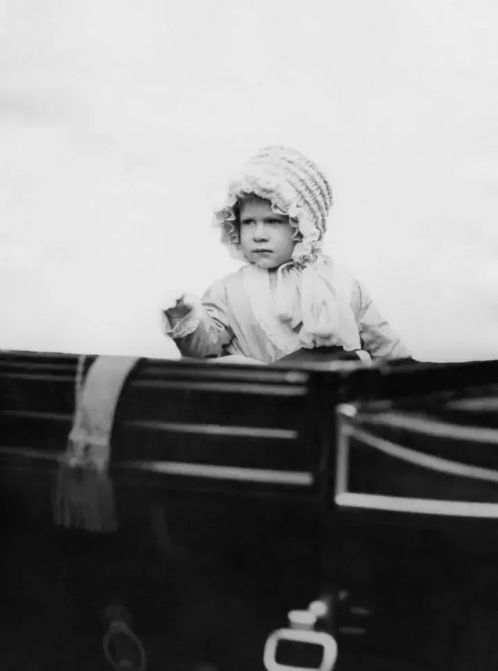 La princesa Isabel saluda desde el carruaje en Londres en 1928.