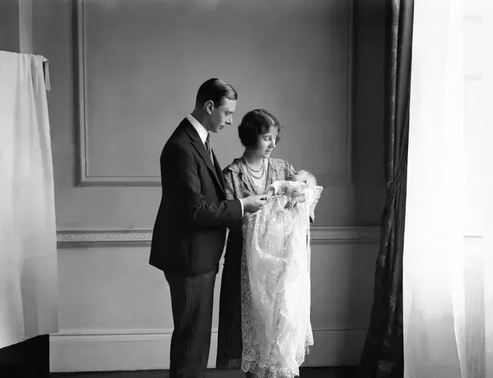 La reina madre (entonces duquesa de York) con su marido, el rey Jorge VI (entonces duque de York), y su hija Isabel II en su bautizo en mayo de 1926.