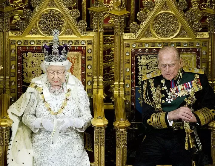 La reina Isabel II y el príncipe Felipe de Edimburgo sentados en los tronos de la Cámara de los Lores en la apertura estatal del Parlamento en 2013.