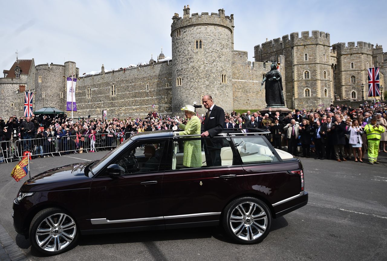 Queen Elizabeth II, accompanied by Prince Philip, Duke of Edinburgh, waves to well-wishers during a walkabout on her 90th birthday in Windsor on April 21, 2016.