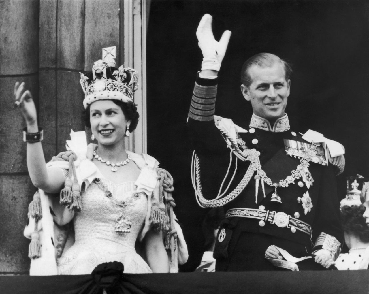 Queen Elizabeth II and the Duke of Edinburgh wave at the crowds from the balcony at Buckingham Palace after Elizabeth's coronation in June 1953.