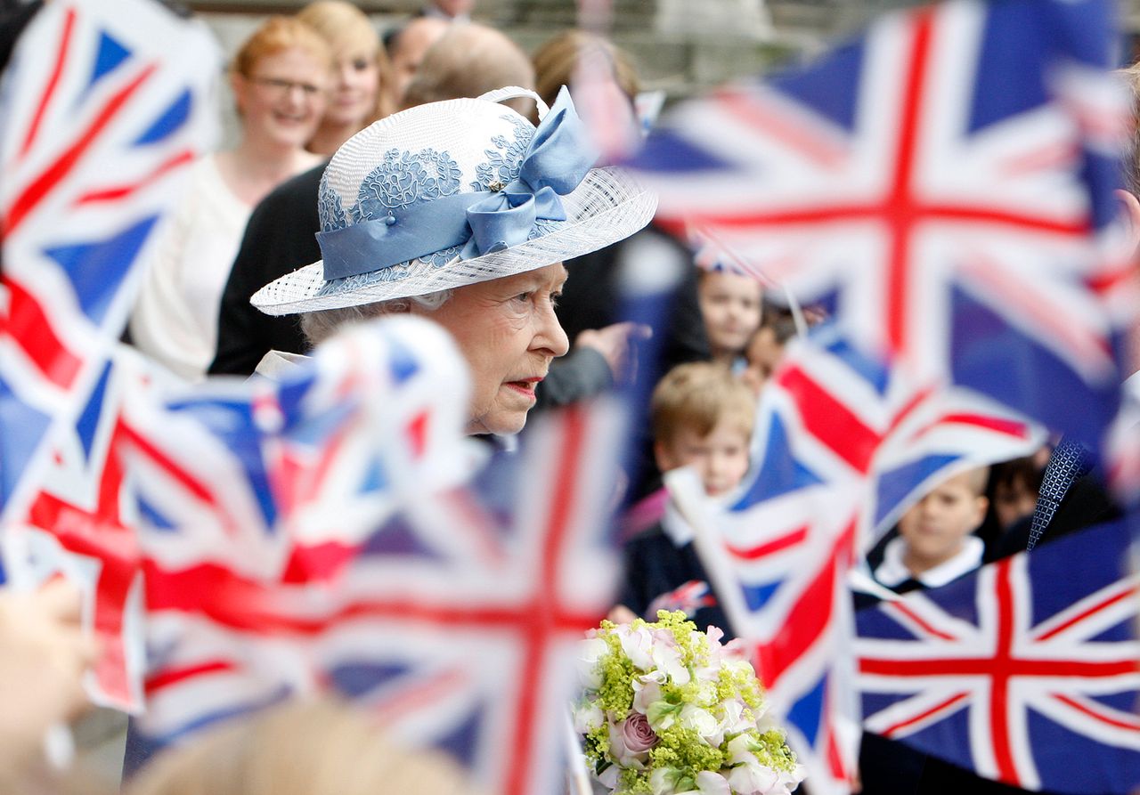Schoolchildren wave Union flags as Queen Elizabeth II leaves St Paul's Cathedral in London on June 21, 2011.