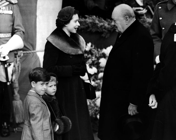 1953: Elizabeth II, Queen of England with Prince Charles and Princess Anne chatting to Sir Winston Churchill.
