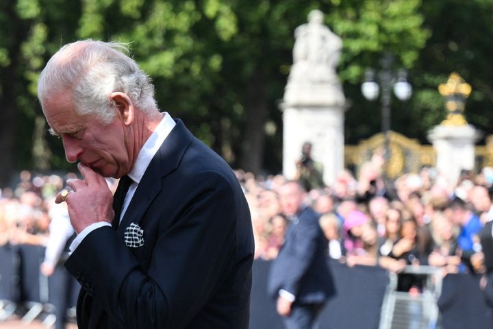 King Charles III looks at floral tributes left outside of Buckingham Palace in London, on Sep. 9, a day after Queen Elizabeth II died at the age of 96.