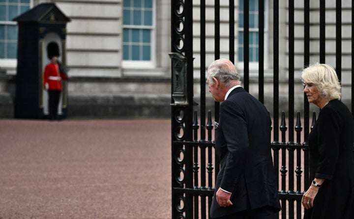 King Charles III and Camilla, Queen Consort, walk into Buckingham Palace after greeting the crowd and looking at floral tributes on Sep. 9. 