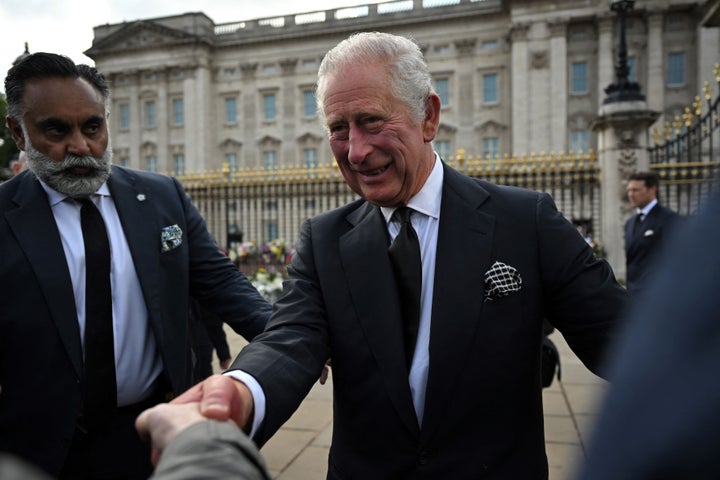 King Charles III greets the members of the public in the crowd upon his arrival at Buckingham Palace. 