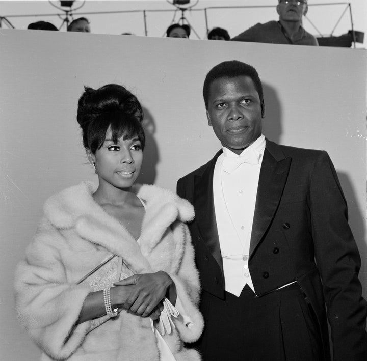 Actor Sidney Poitier with actress Diahann Carroll attend the 36th Academy Awards in Santa Monica, California.