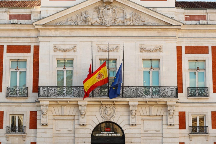 Las banderas de la Comunidad de Madrid, de España y de la UE, a media asta en la sede de la Comunidad de Madrid.