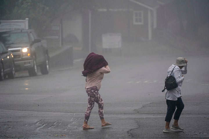 Two people cross the road as wind and rain pummel the area Friday, Sept. 9, 2022, in Julian, California.