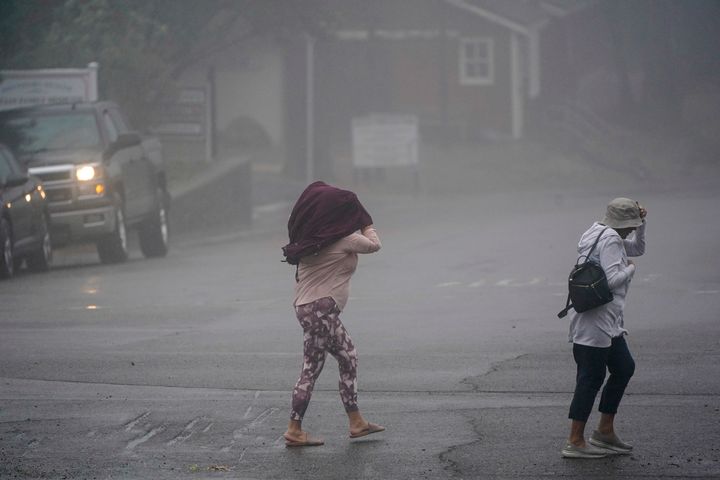 Two people cross the road as wind and rain pummel the area Friday, Sept. 9, 2022, in Julian, California.