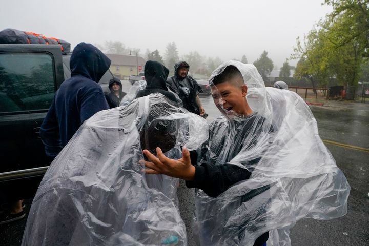 Members of the Ornelas family put on plastic raincoats as wind and rain pummel the area Friday, Sept. 9, 2022, in Julian, California.