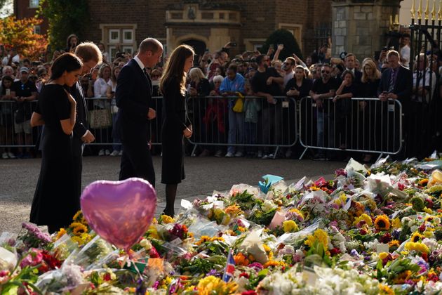 The royal couples look at the piles of floral tributes lining the road in Windsor.
