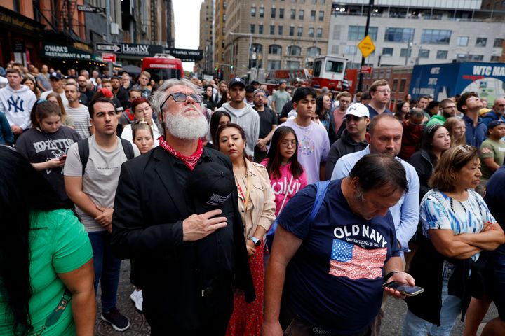 People gather in lower Manhattan near the perimeter of the commemoration ceremony during a moment of silence on the 21st anniversary of the 2001 terror attacks.
