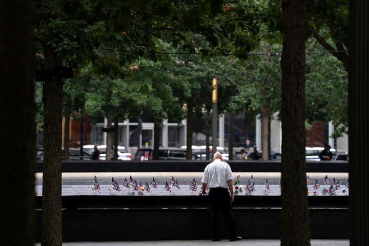 A man places his hand on name engravings during ceremonies to commemorate the 21st anniversary of the Sept. 11 terrorist attacks on Sunday in New York.