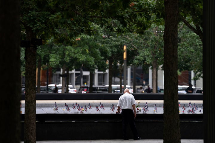 A man places his hand on name engravings during ceremonies to commemorate the 21st anniversary of the Sept. 11 terrorist attacks on Sunday in New York.