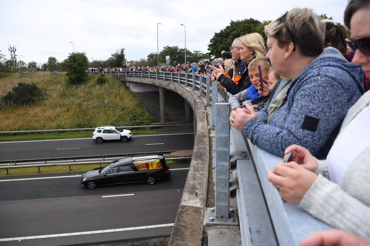 Members of the public stand on a bridge, in Kinross, overlooking the M90 motorway, to pay their respects.