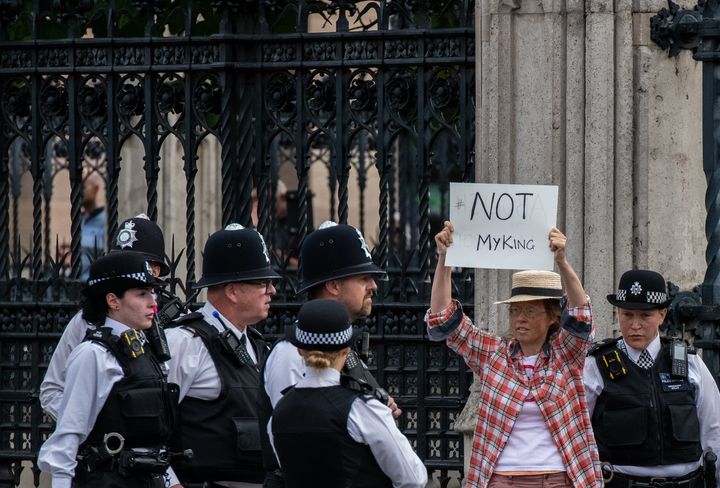 An anti-monarchy protester is escorted by police outside the Houses of Parliament ahead of King Charles address to parliament on Sept. 12, 2022.