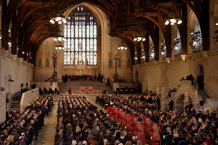 MPs, peers and other guests wait for the King and Queen Consort to arrive at Westminster Hall.