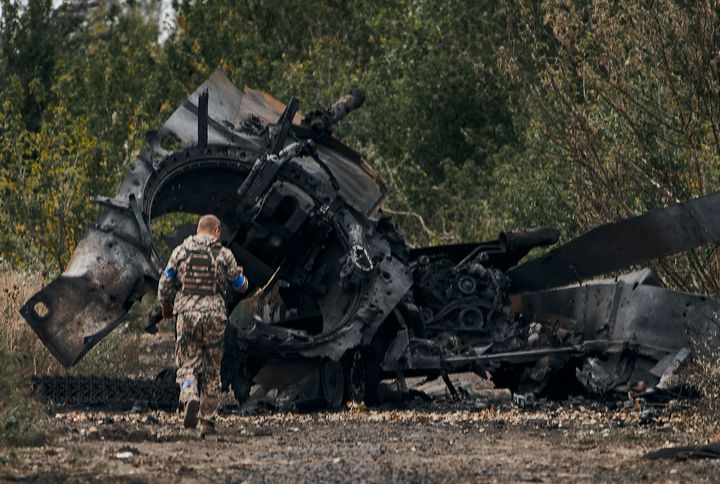 Un soldado ucraniano pasa ante un tanque ruso dañado en el frente de Balakleya, en la región de Jarkov, este domingo.