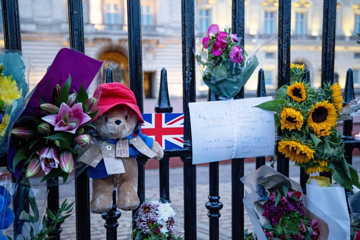 Un ours Paddington avec des messages et des fleurs est suspendu à la porte du palais de Buckingham à Londres.