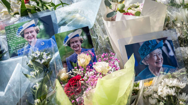 Fotografías de Isabel II y ramos de flores en recuerdo de la difunta reina.