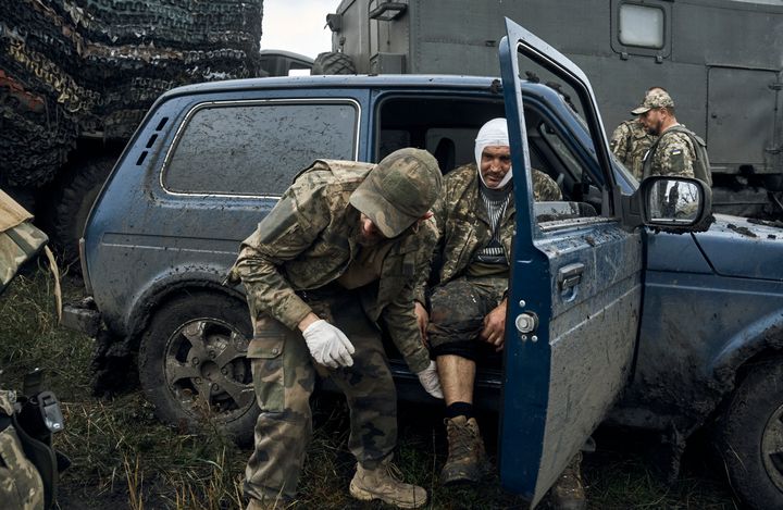 Ένας Ουκρανός στρατιώτης βοηθά τον τραυματισμένο συνάδελφό του σε δρόμο της περιοχής του Χάρκοβο που μόλις απελευθερώθηκε, Ουκρανία, Δευτέρα, 12 Σεπτεμβρίου 2022. Τα ουκρανικά στρατεύματα ανακατέλαβαν μια μεγάλη περιοχή εδάφους από τη Ρωσία τη Δευτέρα, ωθώντας μέχρι τα βορειοανατολικά σύνορα σε ορισμένα σημεία τον ρωσικό στρατό , ενώ ισχυρίστηκε ότι συνέλαβε πολλούς Ρώσους στρατιώτες ως μέρος μιας αστραπιαίας προέλασης που ανάγκασε τη Μόσχα να κάνει μια βιαστική υποχώρηση. (AP Photo/Kostiantyn Liberov)