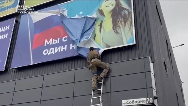 Ένας Ουκρανός στρατιώτης σκίζει ένα πανό, εν μέσω της εισβολής της Ρωσίας στην Ουκρανία, στο Βοβτσάνσκ της Ουκρανίας σε αυτήν την εικόνα, από ένα βίντεο που κυκλοφόρησε στις 13 Σεπτεμβρίου 2022. State Border Service of Ukraine/Handout via REUTERS THIS IMAGE HAS BEEN SUPPLIED BY A THIRD PARTY MANDATORY CREDIT
