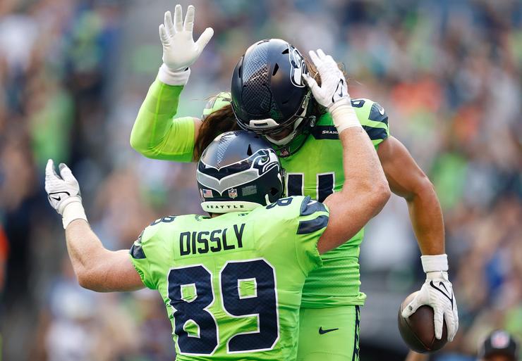 Will Dissly #89 and Colby Parkinson #84 of the Seattle Seahawks celebrate a touchdown scored by Parkinson during the second quarter against the Denver Broncos at Lumen Field on Sept. 12, 2022, in Seattle, Washington.