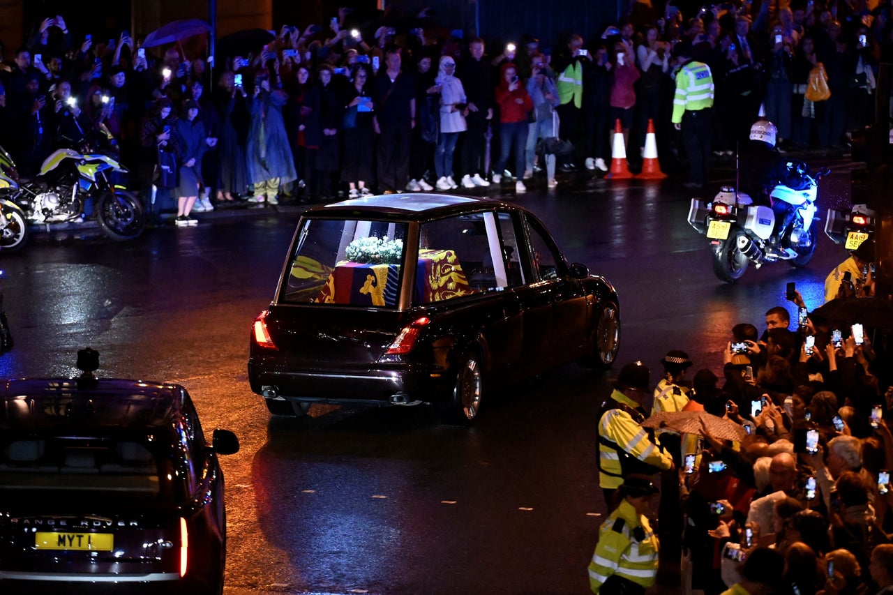 The crowd gather to watch the coffin.