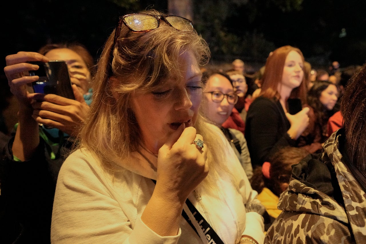 A woman cries as the hearse carrying the coffin of late Queen Elizabeth II passes.