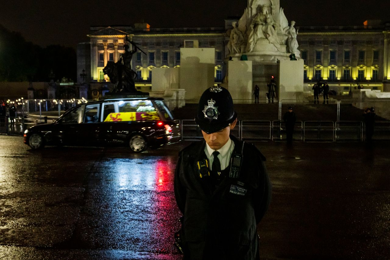 A policeman bows his head as the hearse carrying the coffin of late Queen Elizabeth II, arrives at Buckingham Palace.