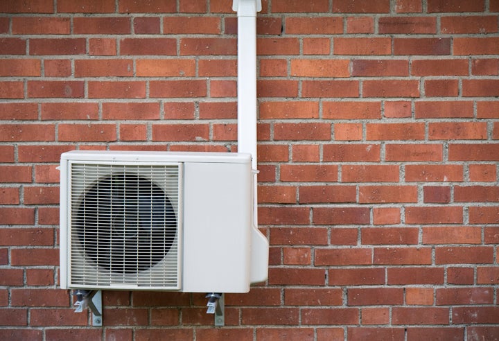 A heat pump on a brick wall