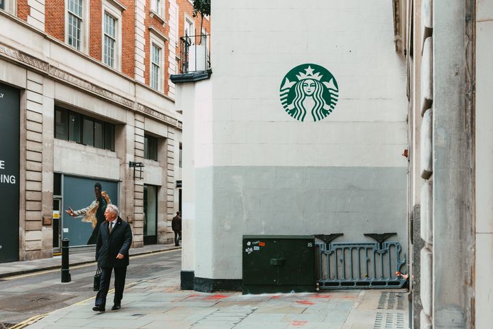 London, UK - 14 March, 2022: people walking outside a Starbucks coffee shop outdoors on a city street in central London, UK.