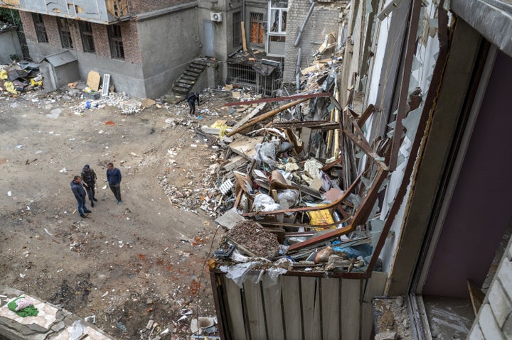 Residents stand in the backyard of their building, which was damaged in a Russian missile attack in the center of Kharkiv, Ukraine, on Tuesday.