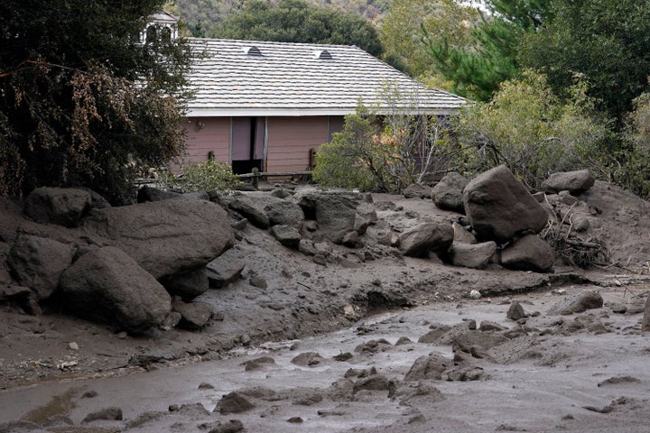 The front yard of a property is covered in mud in the aftermath of a mudslide Tuesday in Oak Glen.