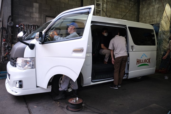 板橋区内の自動車整備工場で警報ブザーを取り付け中のスクールバス（9月13日撮影）