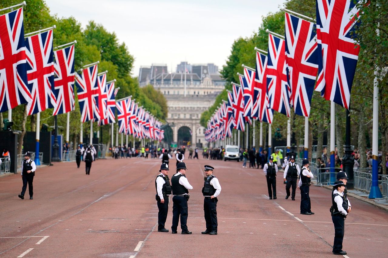 Οι αστυνομικοί φρουρούν στο The Mall πριν από την τελετουργική πομπή του φέρετρου της Βασίλισσας Ελισάβετ Β', από τα Ανάκτορα του Μπάκιγχαμ στο Westminster Hall, στο Λονδίνο, Τετάρτη 14 Σεπτεμβρίου 2022. Η σορός της βασίλισσας θα παραμείνει στο Westminster Hall για τέσσερις ολόκληρες ημέρες πριν την κηδεία της τη Δευτέρα 19 Σεπτεμβρίου. (Dominic Lipinski/PA via AP)
