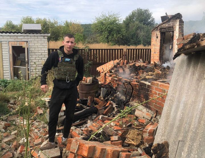 Daniil Ostroverkh stands next to his home that has been destroyed by Russian bombs