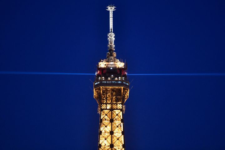 The top of the illuminated Eiffel Tower is pictured at night in Paris on March 8, 2021.