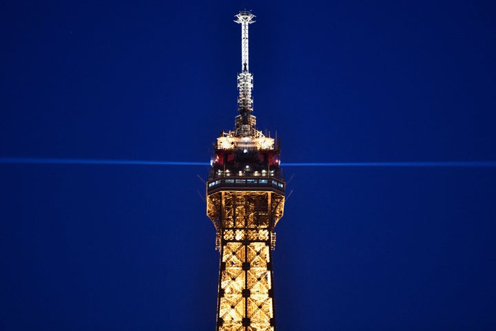 The top of the illuminated Eiffel Tower is pictured at night in Paris on March 8, 2021.