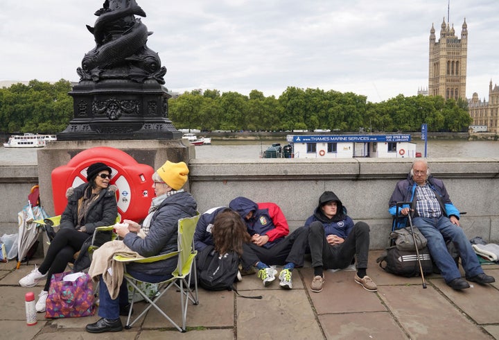 People wait in line to see the queen’s coffin.