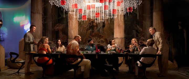 (Left to right) Edward Norton, Madelyn Cline, Kathryn Hahn, Dave Bautista, Leslie Odom Jr., Jessica Henwick, Kate Hudson, Janelle Monae and Daniel Craig gather at the table for the latest "Knives Out" whodunit.