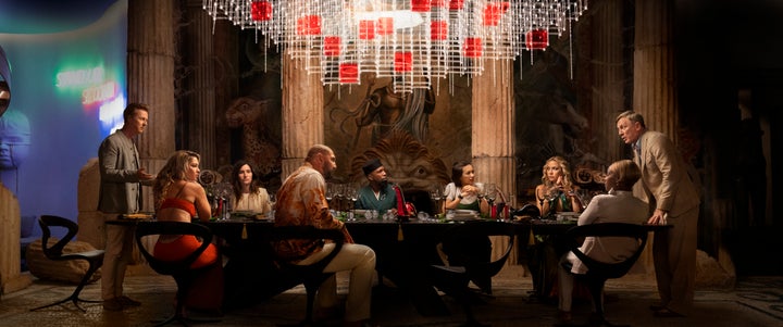 (Left to right) Edward Norton, Madelyn Cline, Kathryn Hahn, Dave Bautista, Leslie Odom Jr., Jessica Henwick, Kate Hudson, Janelle Monae and Daniel Craig gather at the table for the latest "Knives Out" whodunit.