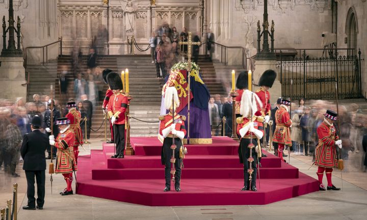 Members of the public as they file past the coffin of Queen Elizabeth II, draped in the Royal Standard with the Imperial State Crown and the Sovereign's orb and sceptre, lying in state on the catafalque in Westminster Hall, at the Palace of Westminster, London, ahead of her funeral on Monday.