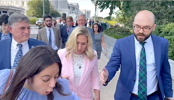 Marianna Pecora stumbles after she said Marjorie Taylor Greene kicked her.