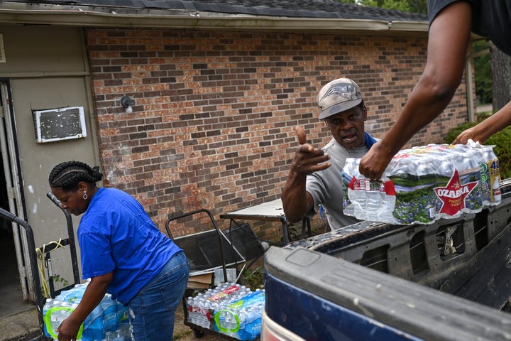 JACKSON MS - SEPTEMBER 3 : Rodney Moore (C), maintenance supervisor at Addison Place apartments receives cases of bottle water from City of Jackson worker Dianna Davis (R) and Andrea Williams for elderly and disabled residents on September 3, 2022 in Jackson, Mississippi. The entire city of Jackson has been suffering from unsafe drinking water for years causing forcing residents to use bottle water to drink, cook and brush their teeth. Flooding in the area in the last week has caused the treatment facility to malfunction leaving residents without water to bathe or even flush toilets. 