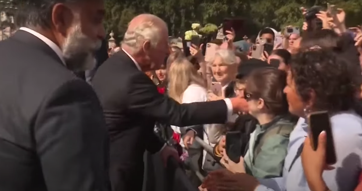 El rey Carlos III, acompañado de sus guardaespaldas, saluda a varios británicos.